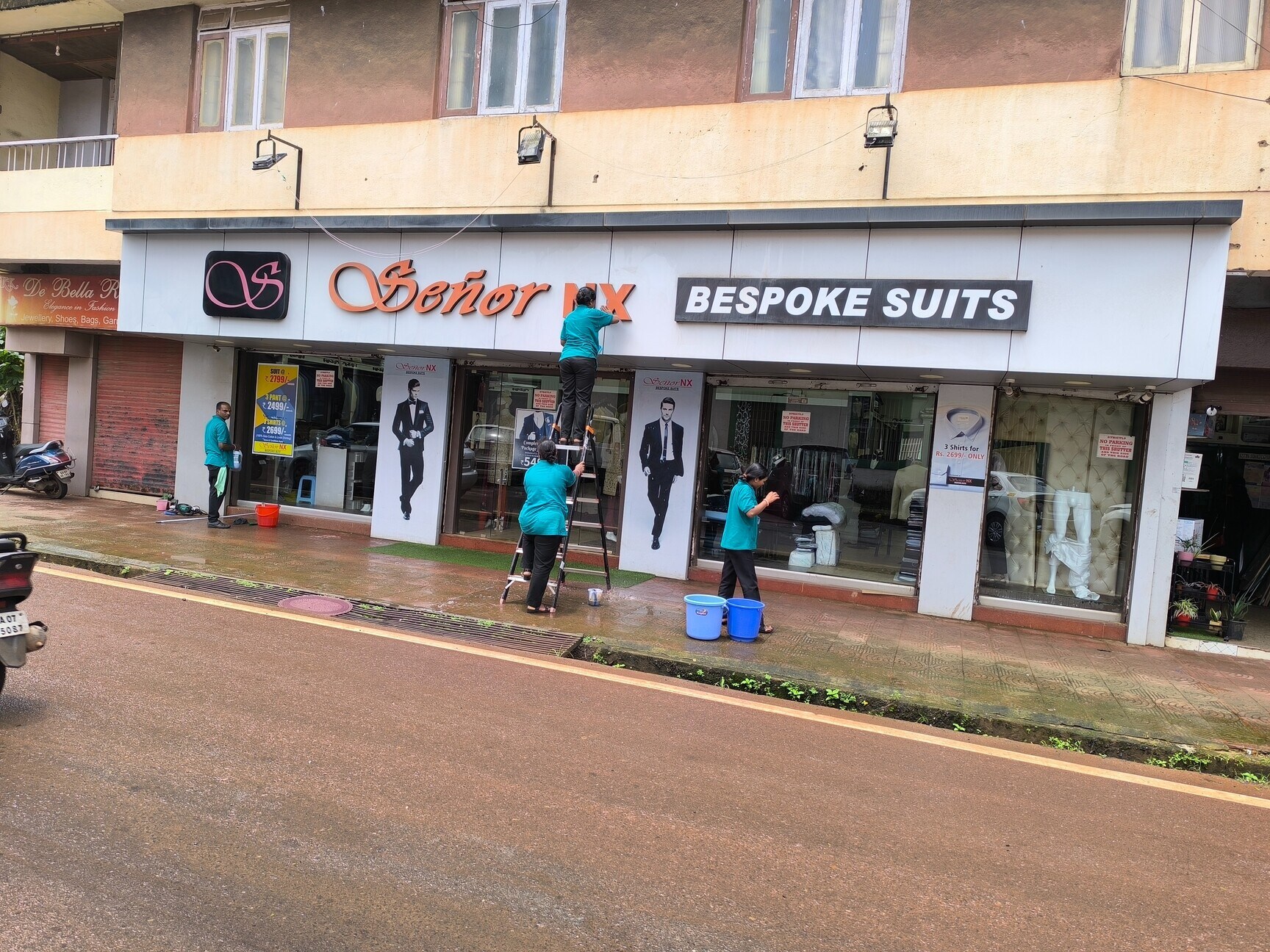 Team cleaning the glass shopfront of a retail showroom in Goa