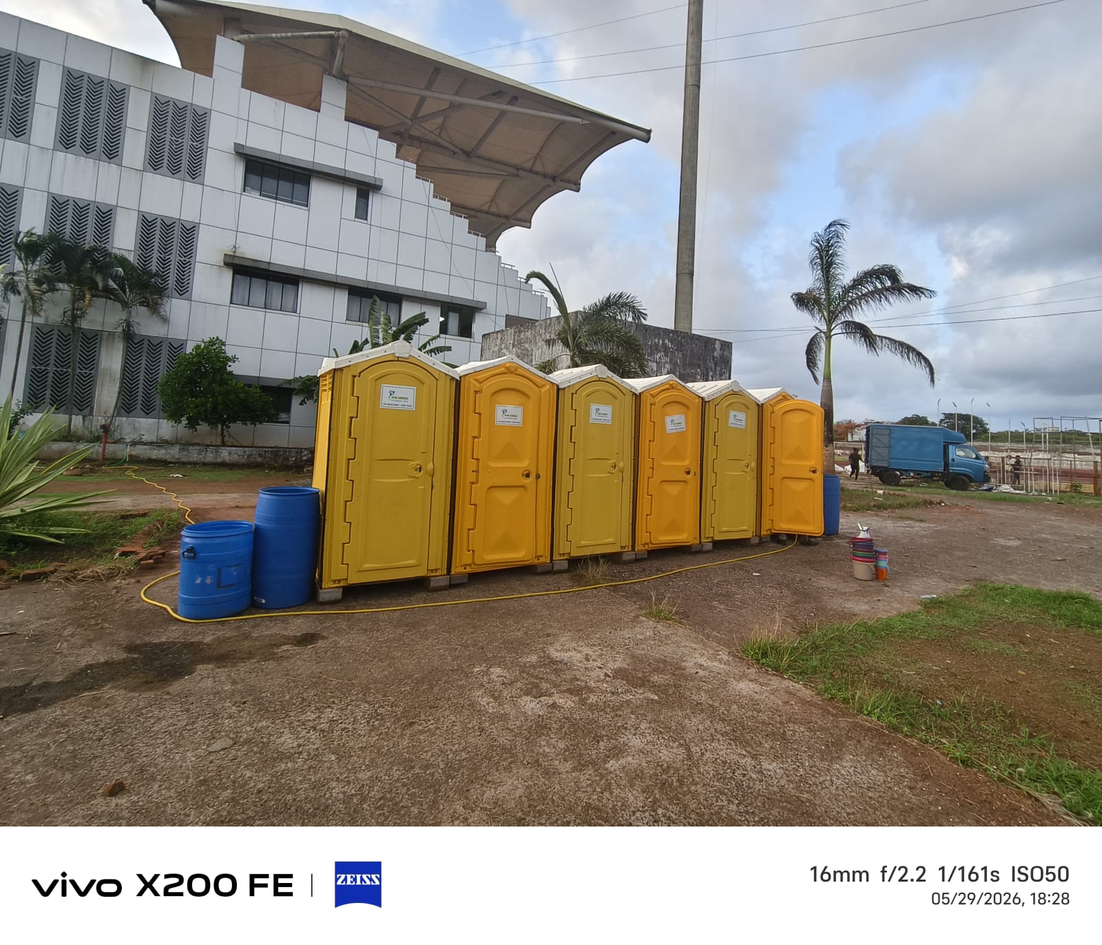 Row of yellow portable toilet cabins installed at an event ground in Goa
